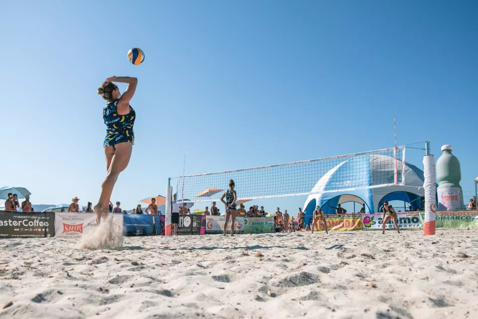 Battuta in salto durante un torneo di beach volley